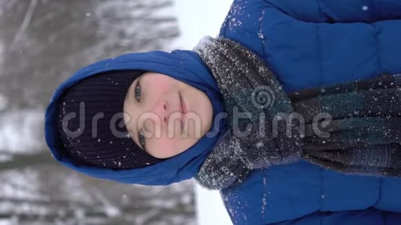 冬天森林里一个年轻人的肖像大雪纷飞视频的预览图