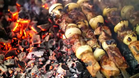 烤串烹饪在金属串上关闭烤肉时烤熟的肉用木炭和火焰烧烤野餐视频的预览图