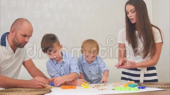 年轻的父母教他们的小男孩如何做饼干视频的预览图