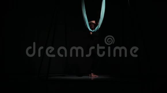 空中瑜伽课上一个苗条的女孩在黑暗中跳舞视频的预览图