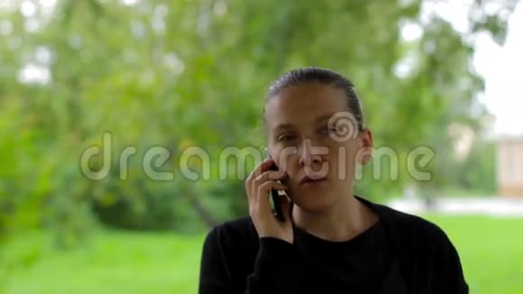 自信的年轻女商人在绿色公园打电话视频的预览图
