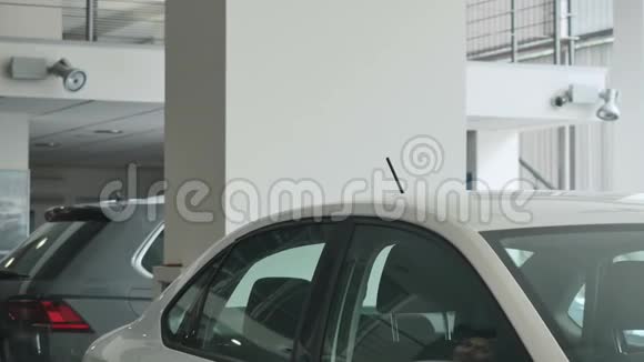 一个肮脏的男人在检查一个白色汽车沙龙视频的预览图