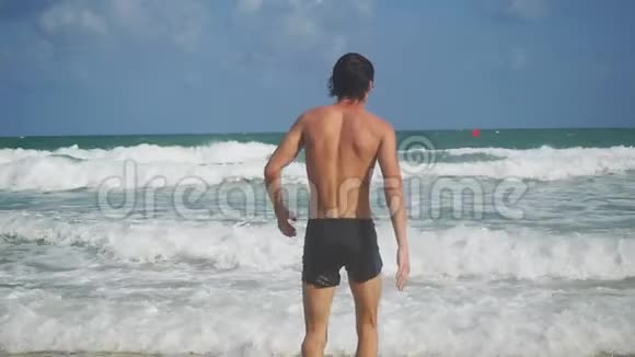 英俊的年轻人慢吞吞地跑进大海快乐的暑假游泳在波浪上放松娱乐1920x1080视频的预览图