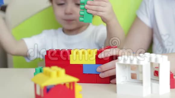 孩子的手在白色背景上收集彩色积木视频的预览图