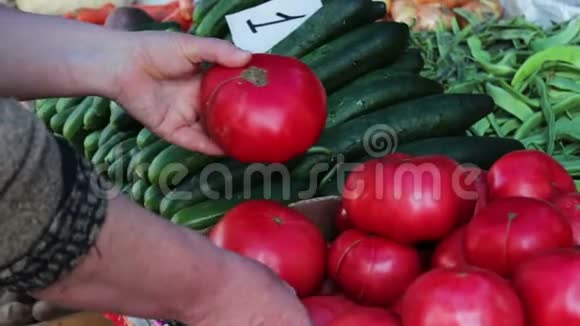 女人在市场上选择大的新鲜西红柿视频的预览图