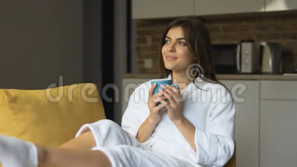 女孩在扶手椅上享受咖啡视频的预览图