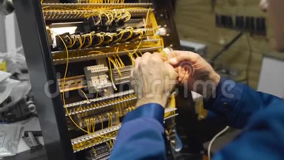 电工将电线卷起来在仪表盘的一个电路中用高压工作视频的预览图