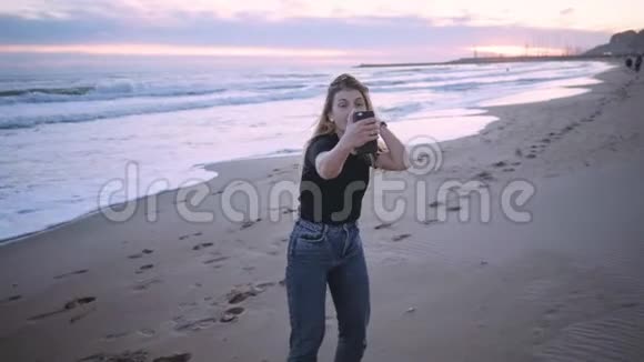 日落或黄昏时分海滩上快乐的金发女孩视频的预览图