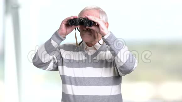 一个年长的男人透过一双望远镜视频的预览图
