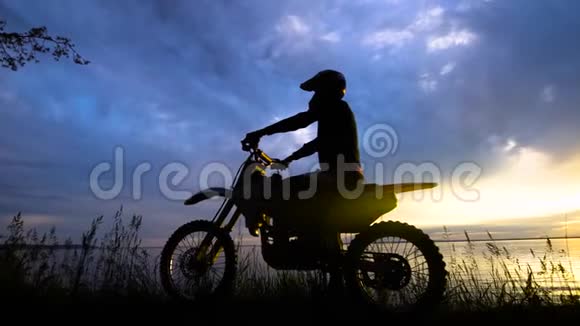 日落时分骑摩托车的人黑色轮廓视频的预览图
