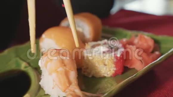 日本餐馆里女人用筷子蘸寿司和虾酱视频的预览图