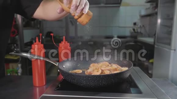 厨师将香料倒入炒虾锅上特写慢动作视频的预览图