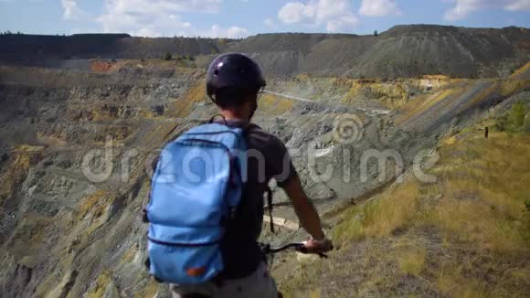一个骑自行车的年轻人沿着峡谷的悬崖骑行视频的预览图