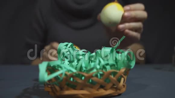 用手在灰色的桌子上用蛋壳小鸡制作复活节纪念品视频的预览图