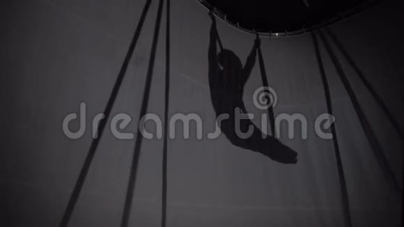 一个女孩在空中挂在吊床上的剪影视频的预览图