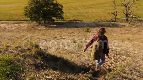 流浪女孩从山上下来徒步旅行者女孩日落时旅行的游客家庭带背包的姐妹视频的预览图