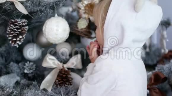 圣诞树附近的女孩这孩子对树上的装饰品很满意视频的预览图