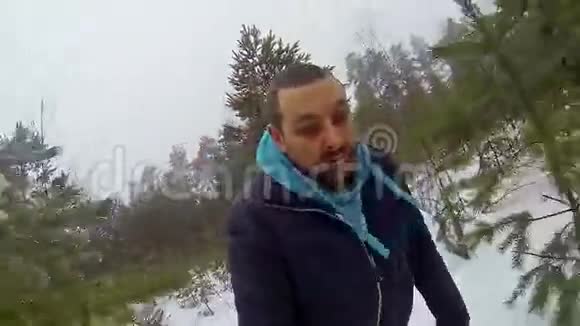 年轻的受惊的人穿过冬天的森林视频的预览图