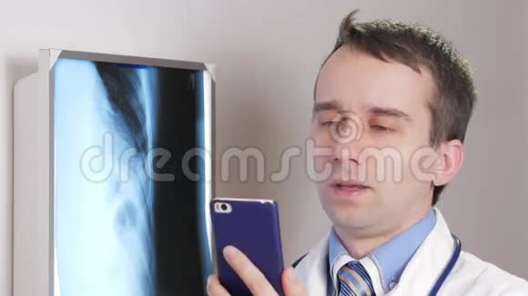 一位年轻的医生在诊所里用电话一名男子记录了一名病人x线的结果视频的预览图