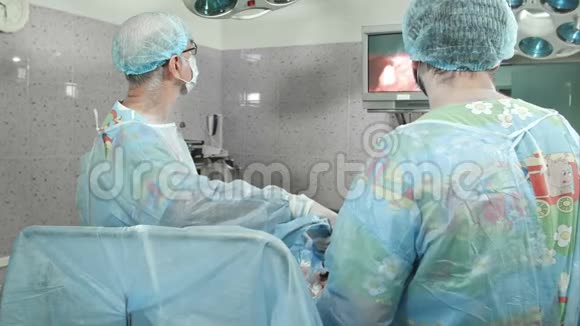 外科医生跟随腹腔镜手术看着屏幕视频的预览图