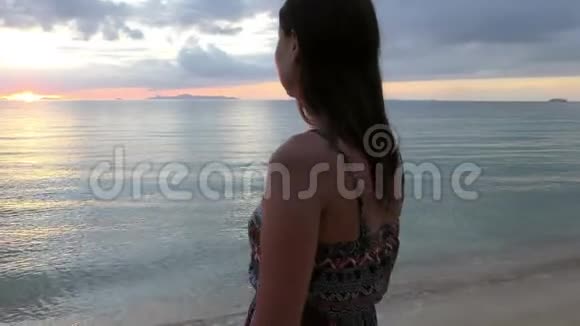 美丽的女人在海滩上享受日落视频的预览图