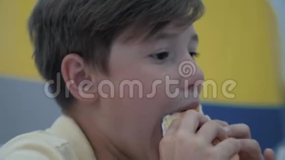 这个男孩在快餐店吃饭有害和可口的食物视频的预览图