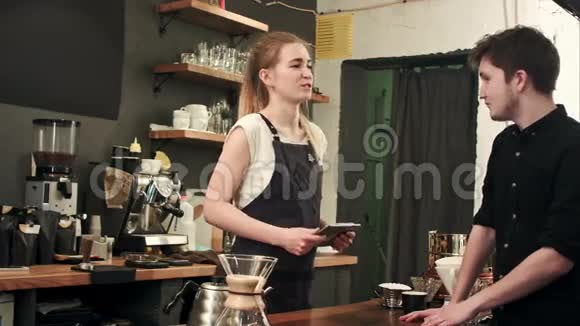 女咖啡师在一家咖啡馆和顾客交谈点餐视频的预览图