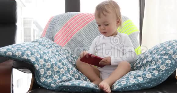 幼儿坐椅和玩智能手机视频的预览图