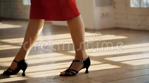一个男人和一个女人的腿的特写在房间里跳一对舞厅舞探戈的舞步视频的预览图