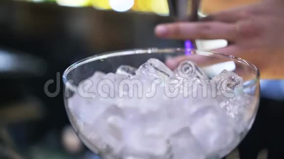 把一个酒保把伏特加加到加冰的鸡尾酒杯里视频的预览图
