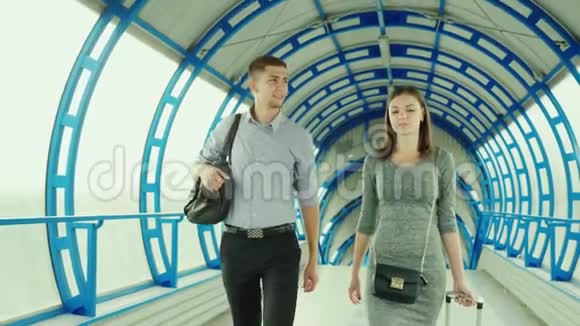 商业伙伴一男一女在车站或机场的终点站携带行李出差团队视频的预览图