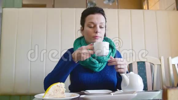 在咖啡馆里喝茶的女孩她坐在桌子旁望着窗外视频的预览图
