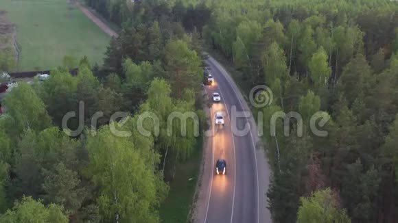 从空中俯瞰蜿蜒于树木之间的乡村道路视频的预览图