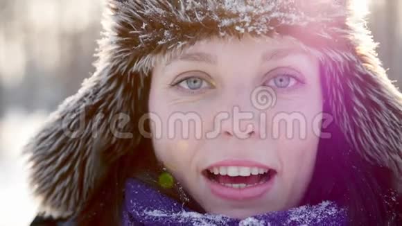 年轻女子在阳光明媚的冬季公园微笑玩得很开心视频的预览图