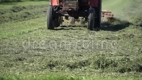 拖拉机在近距离缓慢的运动中培育草为冬天做准备视频的预览图