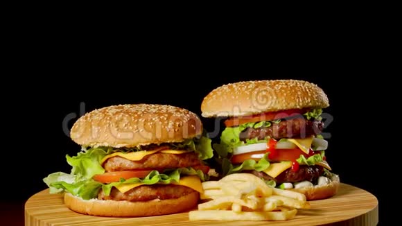 两个工艺牛肉汉堡在木桌上隔离在黑暗的灰度背景视频的预览图