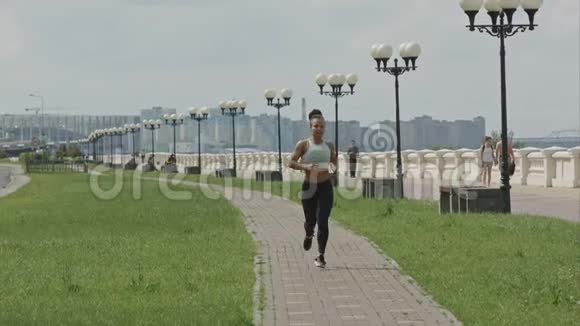 年轻女子奔跑在城市桥路上视频的预览图