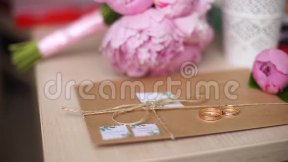 美丽的结婚戒指躺在信封上背景是一束鲜花视频的预览图