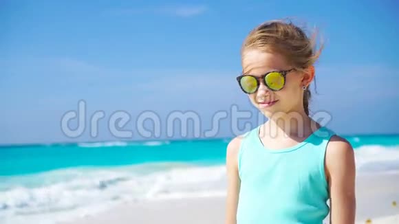 白色海滩上的小女孩夏日热带假日可爱孩子的肖像视频的预览图