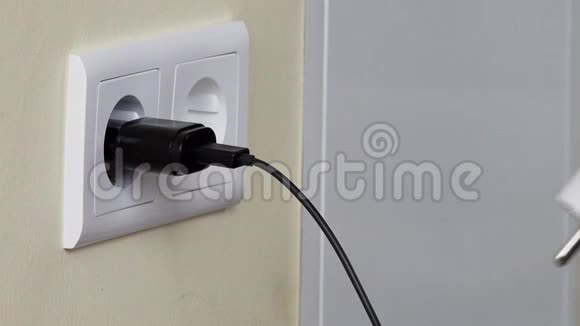 墙上插座附近手机充电器的手插线视频的预览图