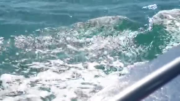 小径水蓝色海面后浮船与泡沫和波浪接近带着溢出气泡的海水视频的预览图