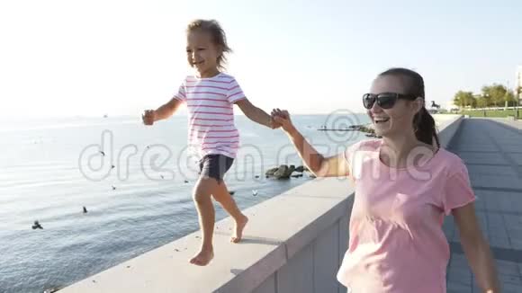 年轻的母亲和小女儿牵着手跑着笑着笑着视频的预览图