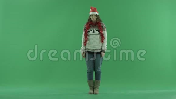 使用虚拟触屏技术制作圣诞帽的迷人年轻女性背景色键视频的预览图