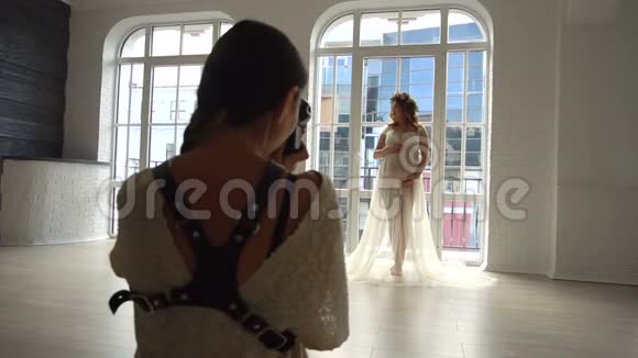 年轻的欧洲孕妇穿着白皮衣在摄影棚拍照视频的预览图