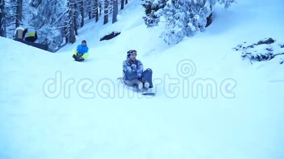 滑雪者在靠近森林房屋的滑雪板上玩得很开心视频的预览图