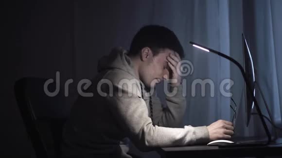 疲惫的年轻作家晚上在电脑上工作视频的预览图