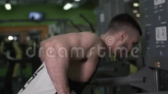肌肉男在健身房的双杠上做三头肌运动的特写视频的预览图