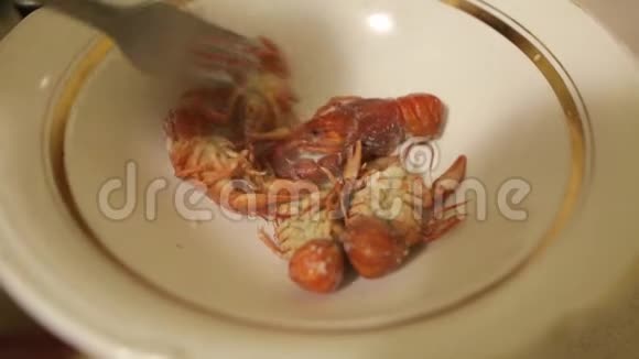一个面目全非的人的手摊开了一盘红煮小龙虾在家煮的新鲜海产食品视频的预览图