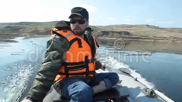 一个留着胡子的人在河边的pvc船上游泳视频的预览图