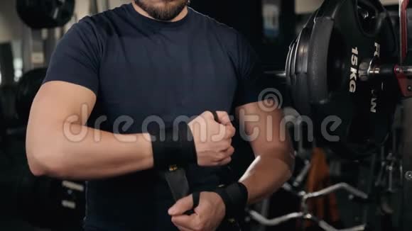一个强壮的拳击手的特写他穿上红色的带子准备战斗准备锻炼训练视频的预览图